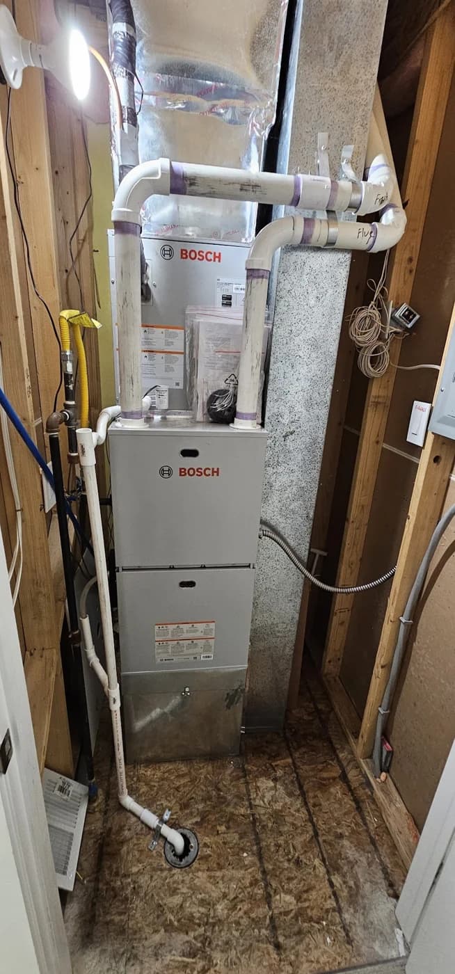 Basement furnace with overhead sheet metal ducts and exposed wood framing