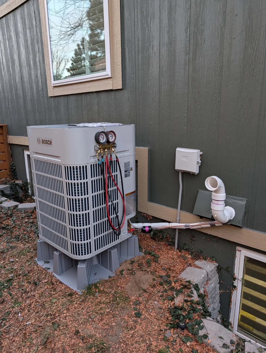 Refrigerant gauges connected to a Bosch outdoor unit during testing